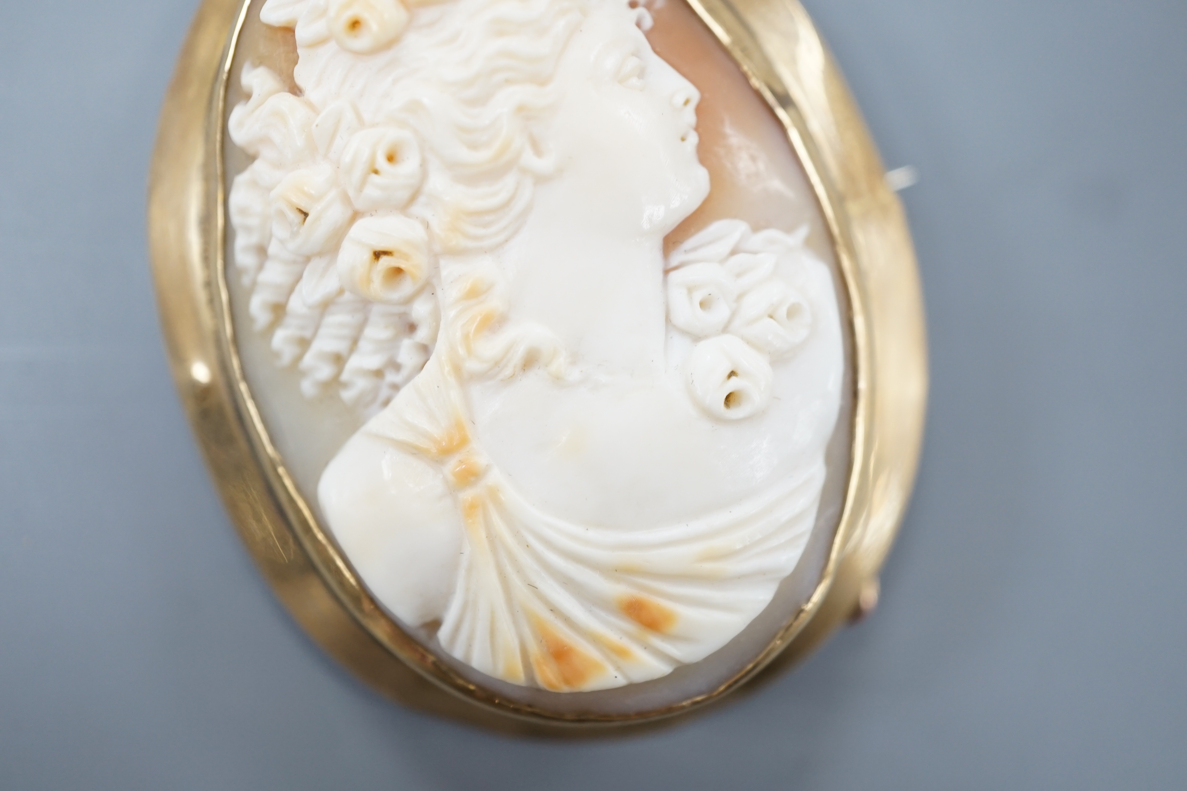 A yellow metal mounted oval cameo shell brooch, carved with the bust of a lady to sinister, 51mm, gross 16 grams.